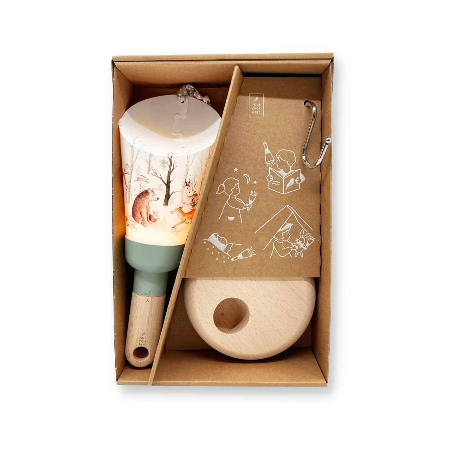 La lampe nomade aux motifs de foret enchantée est installée dans la boite en carton dans laquelle elle est livrée avec son socle et le crochet pour la suspendre.