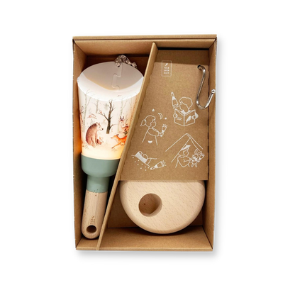 La lampe nomade aux motifs de foret enchantée est installée dans la boite en carton dans laquelle elle est livrée avec son socle et le crochet pour la suspendre.